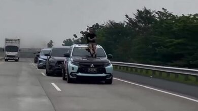 Ahli konvoi duduk atas cermin kereta bergerak