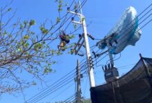 Lelaki tergantung terbalik di tiang elektrik