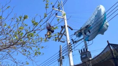 Lelaki tergantung terbalik di tiang elektrik