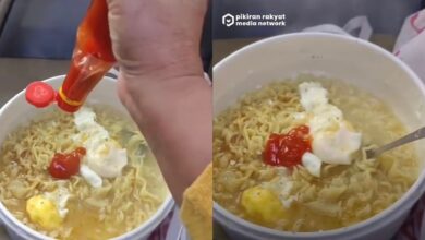 Wanita selamba masak mi segera dalam kereta api