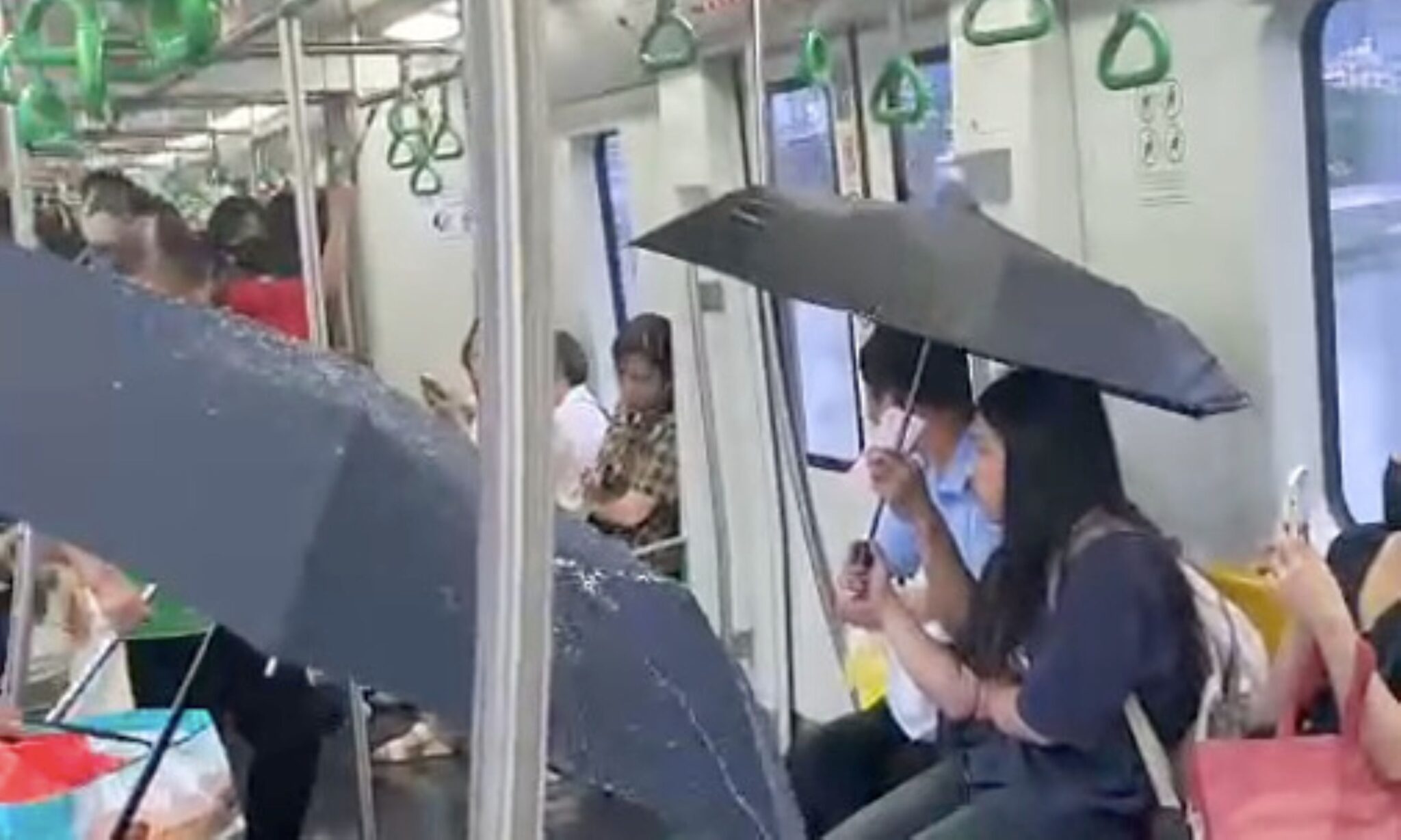 Penumpang guna payung dalam tren