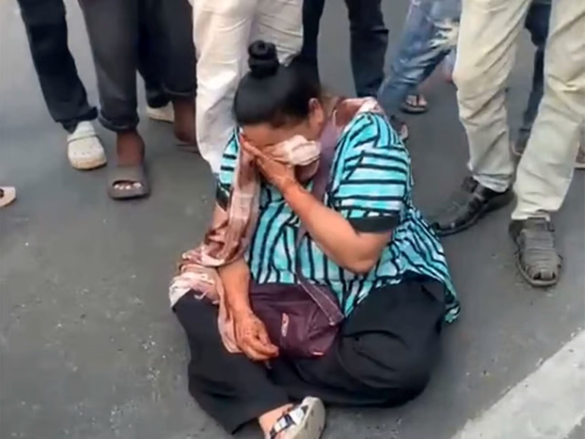 Wanita duduk di tengah jalan, merajuk roti puri tidak cukup